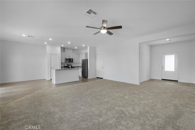 unfurnished living room with light hardwood / wood-style flooring and ceiling fan