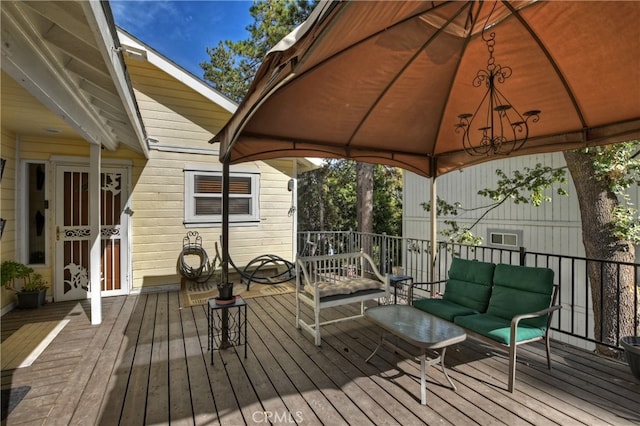 wooden terrace featuring a gazebo and an outdoor living space