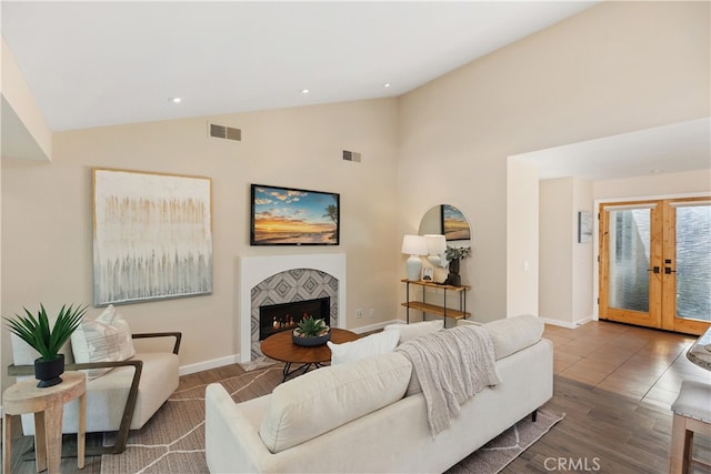 living room featuring french doors, high vaulted ceiling, and hardwood / wood-style flooring