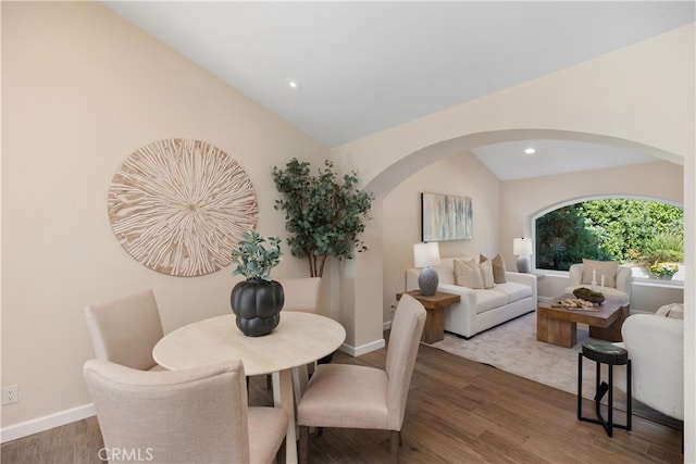 dining space with lofted ceiling and dark wood-type flooring