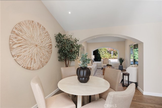 dining area featuring lofted ceiling and wood-type flooring