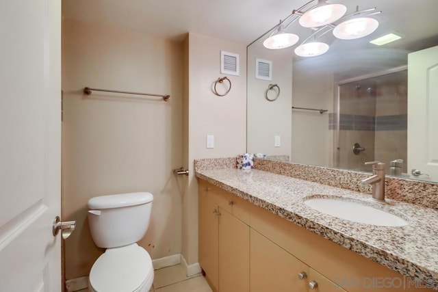 bathroom featuring toilet, an enclosed shower, vanity, and tile patterned floors