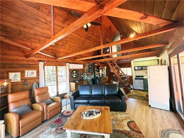 living room with wooden ceiling, light wood-type flooring, wood walls, an AC wall unit, and lofted ceiling with beams