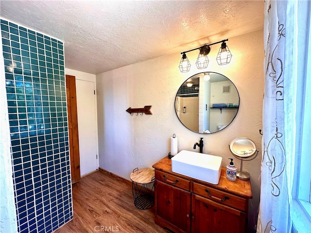 bathroom featuring vanity, hardwood / wood-style floors, and a textured ceiling