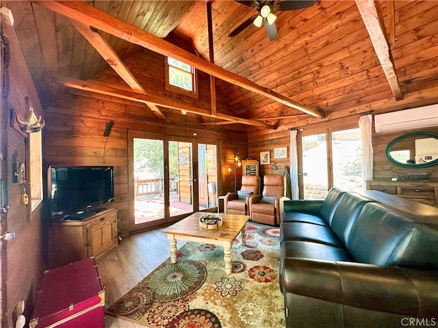 living room featuring hardwood / wood-style flooring, a wall mounted AC, a wealth of natural light, and vaulted ceiling with beams