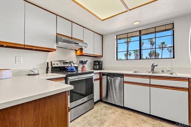 kitchen featuring white cabinets, sink, light tile patterned floors, and stainless steel appliances