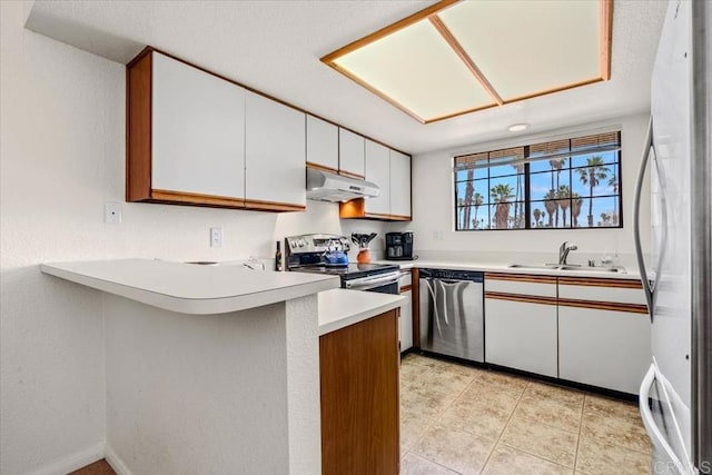 kitchen featuring sink, white cabinetry, appliances with stainless steel finishes, and kitchen peninsula