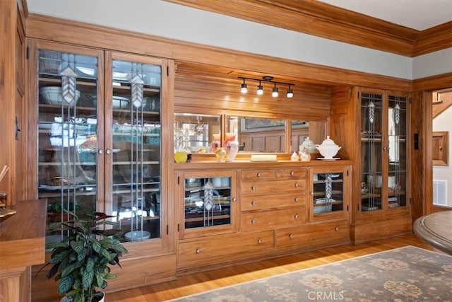 bar featuring crown molding and hardwood / wood-style flooring