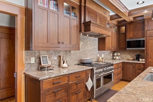 kitchen with tasteful backsplash, double oven range, black microwave, and light stone counters