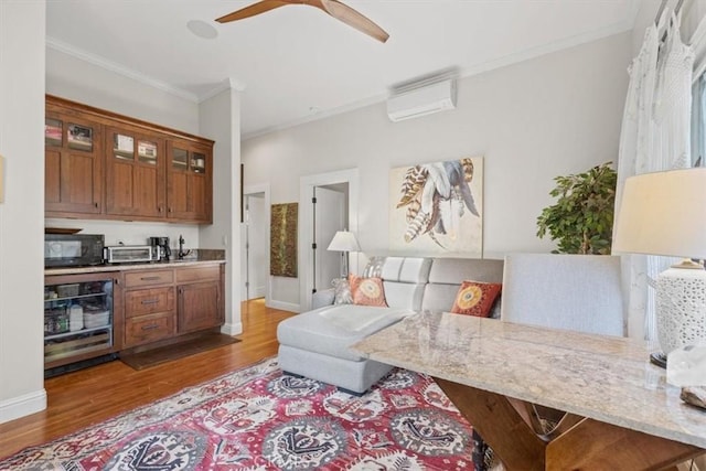 living room with wine cooler, ceiling fan, a wall unit AC, light hardwood / wood-style flooring, and ornamental molding