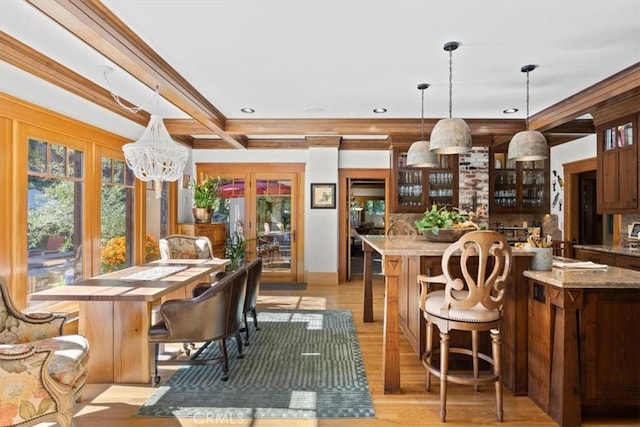 kitchen featuring decorative light fixtures, an inviting chandelier, light wood-type flooring, light stone countertops, and french doors