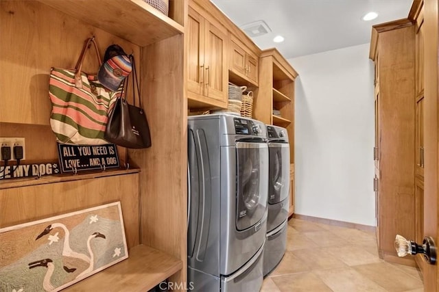 washroom with washer and dryer and cabinets