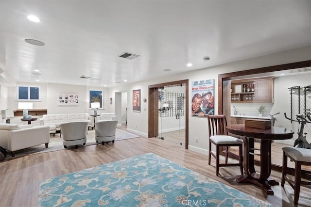 interior space featuring bar and light hardwood / wood-style floors