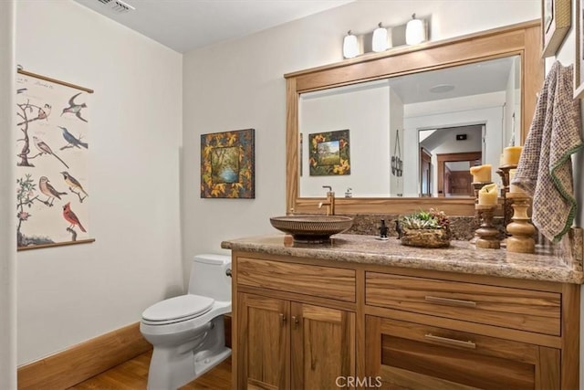 bathroom with toilet, wood-type flooring, and vanity