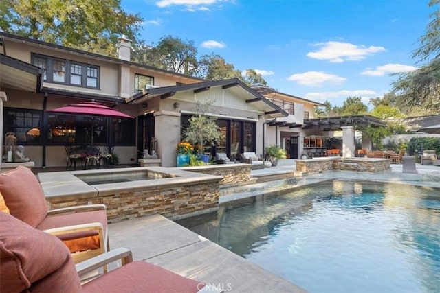 rear view of house with pool water feature, a swimming pool with hot tub, and a patio area