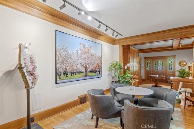 dining space with beam ceiling and light wood-type flooring