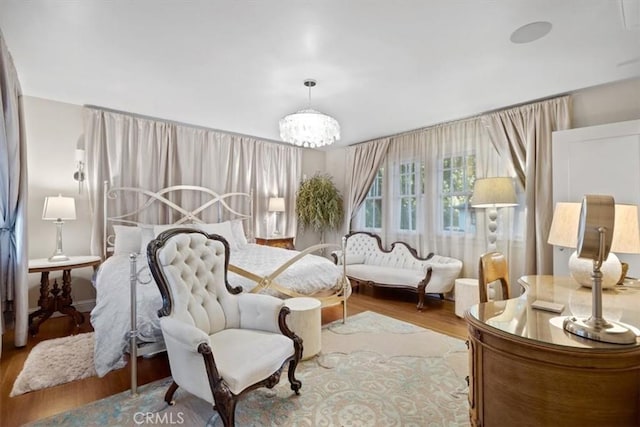 sitting room with an inviting chandelier and hardwood / wood-style flooring