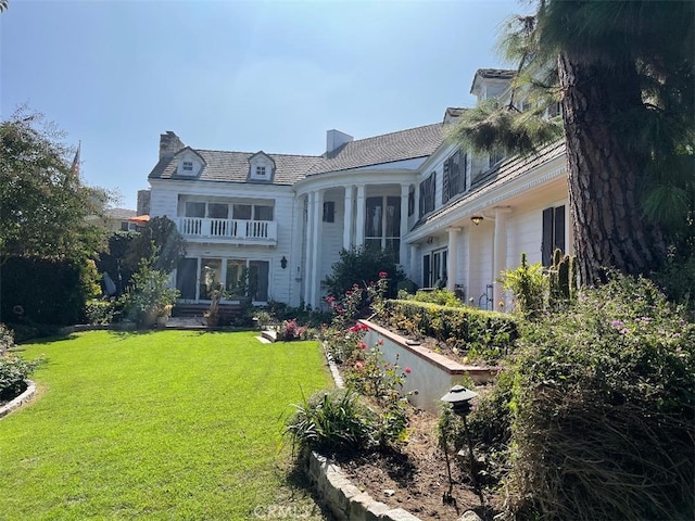 rear view of house featuring a yard