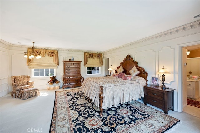 carpeted bedroom featuring an inviting chandelier and ensuite bath