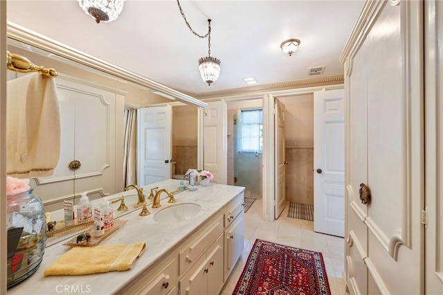 bathroom featuring vanity, ornamental molding, a notable chandelier, and tile patterned flooring