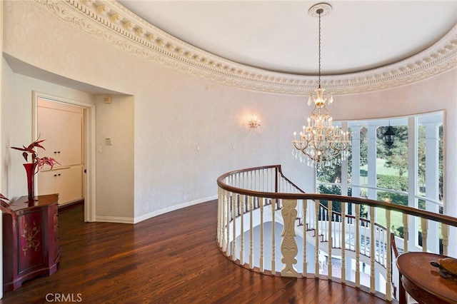 corridor with dark hardwood / wood-style flooring, crown molding, and a notable chandelier