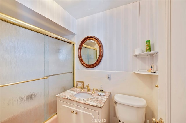 full bathroom featuring toilet, vanity, and shower / bath combination with glass door