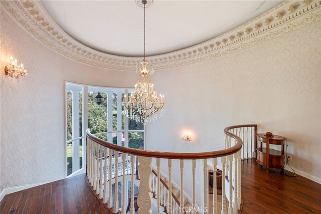 hallway with dark wood-type flooring, an inviting chandelier, and ornamental molding