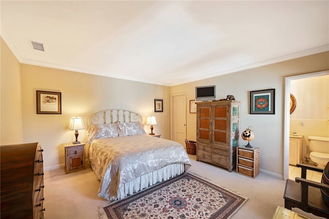 carpeted bedroom with ensuite bathroom and ornamental molding