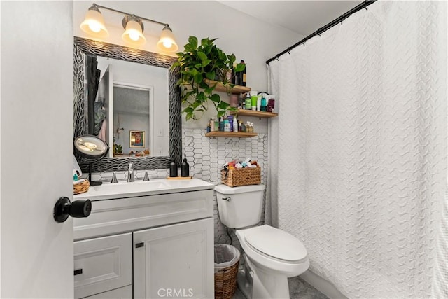 bathroom featuring decorative backsplash, vanity, and toilet