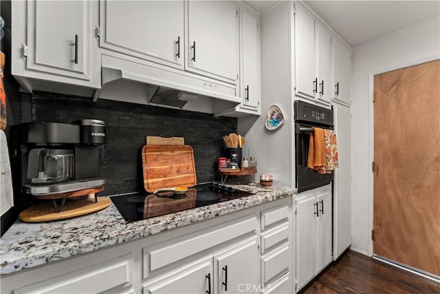 kitchen with tasteful backsplash, white cabinetry, and black appliances