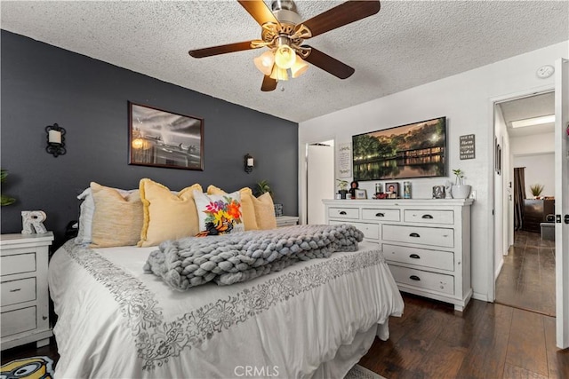 bedroom with a textured ceiling, dark hardwood / wood-style floors, and ceiling fan