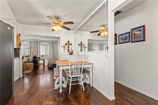 dining space with dark hardwood / wood-style flooring and a textured ceiling