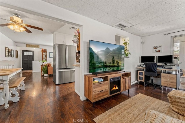 home office with ceiling fan, a drop ceiling, and dark wood-type flooring