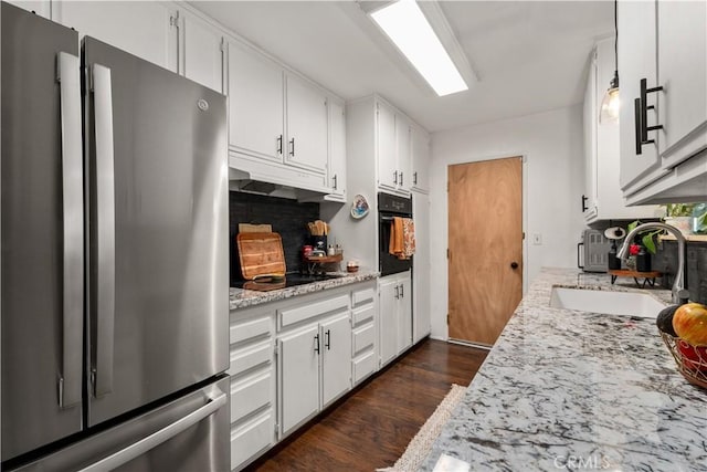 kitchen with light stone countertops, sink, dark hardwood / wood-style floors, white cabinets, and black appliances