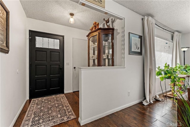 foyer featuring dark hardwood / wood-style flooring and a textured ceiling