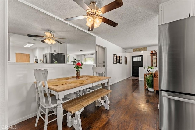 dining room featuring a textured ceiling, ceiling fan, and dark wood-type flooring