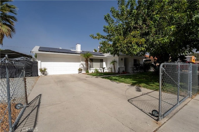 ranch-style home featuring solar panels, a garage, and a front lawn