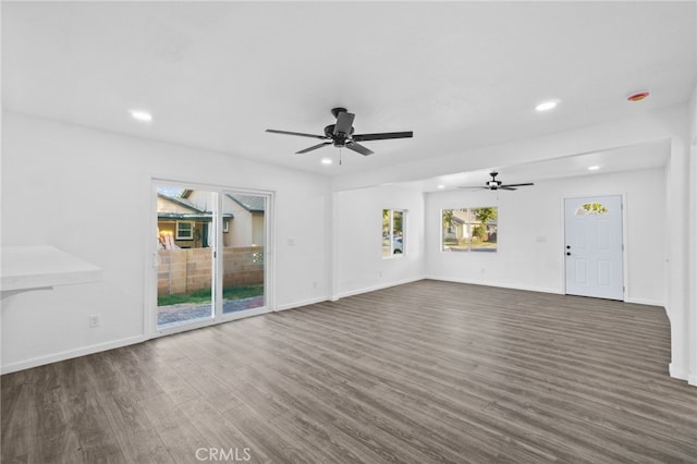 unfurnished living room with dark hardwood / wood-style floors and ceiling fan