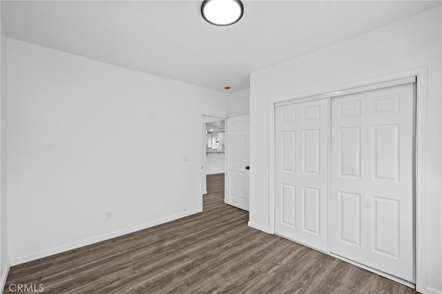 unfurnished bedroom featuring dark wood-type flooring and a closet