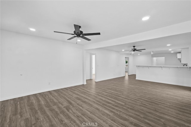 unfurnished living room with dark wood-type flooring and ceiling fan