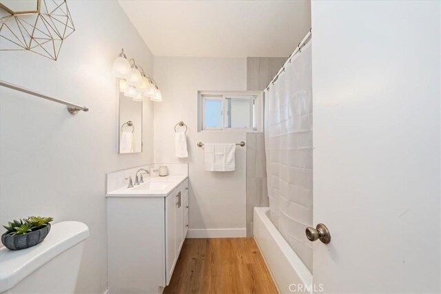 full bathroom with vanity, shower / bath combo with shower curtain, wood-type flooring, and toilet