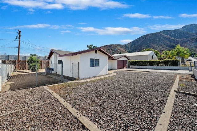 exterior space with central air condition unit, a mountain view, and a garage