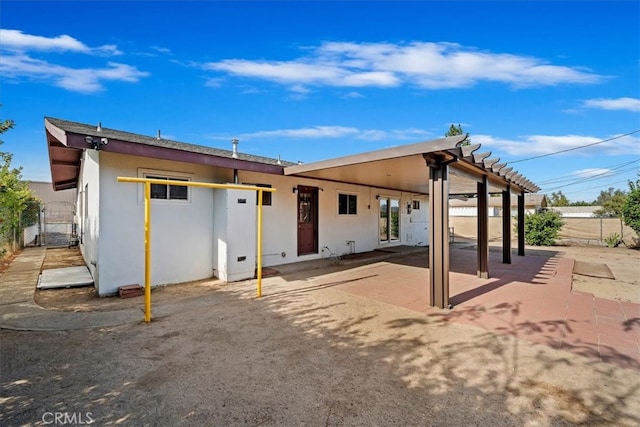 rear view of property with a patio area and a pergola