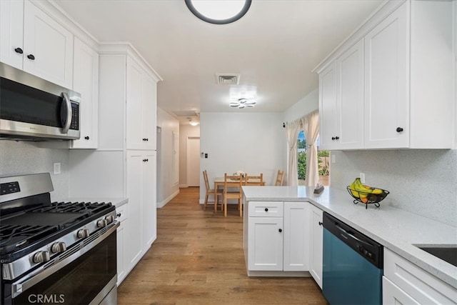 kitchen featuring light hardwood / wood-style floors, kitchen peninsula, white cabinets, and stainless steel appliances