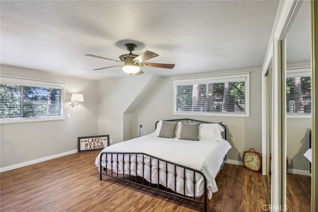 bedroom with multiple windows, hardwood / wood-style floors, and ceiling fan