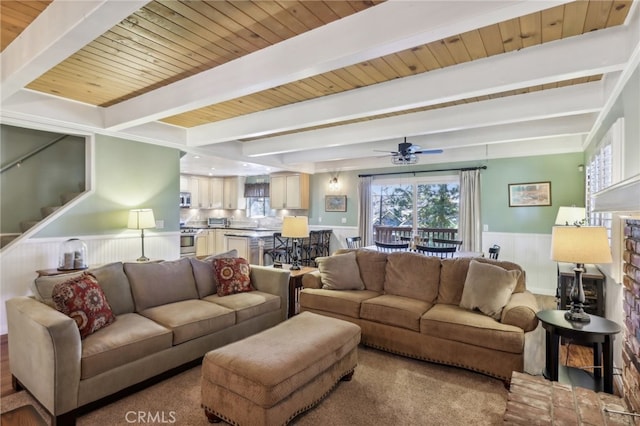 living room featuring beam ceiling, wooden ceiling, and ceiling fan