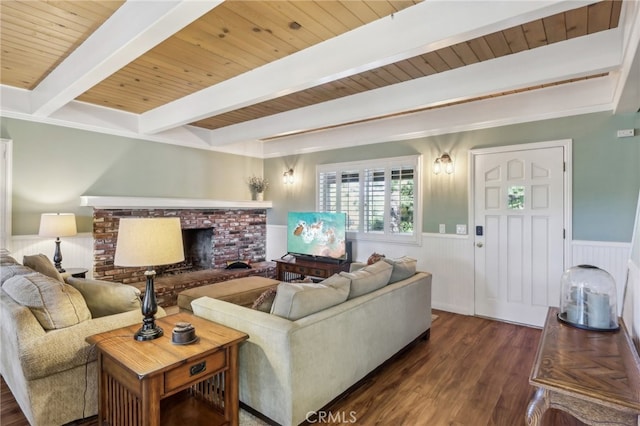 living room with beam ceiling, wooden ceiling, dark hardwood / wood-style flooring, and a brick fireplace