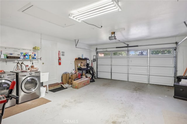 garage with a garage door opener and washer and dryer