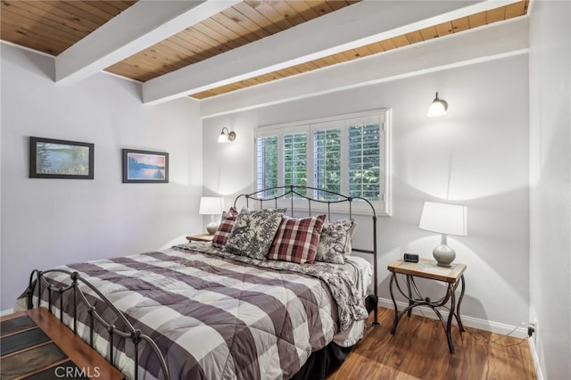 bedroom with beam ceiling, hardwood / wood-style floors, and wooden ceiling