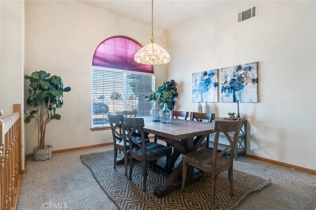 carpeted dining space with an inviting chandelier